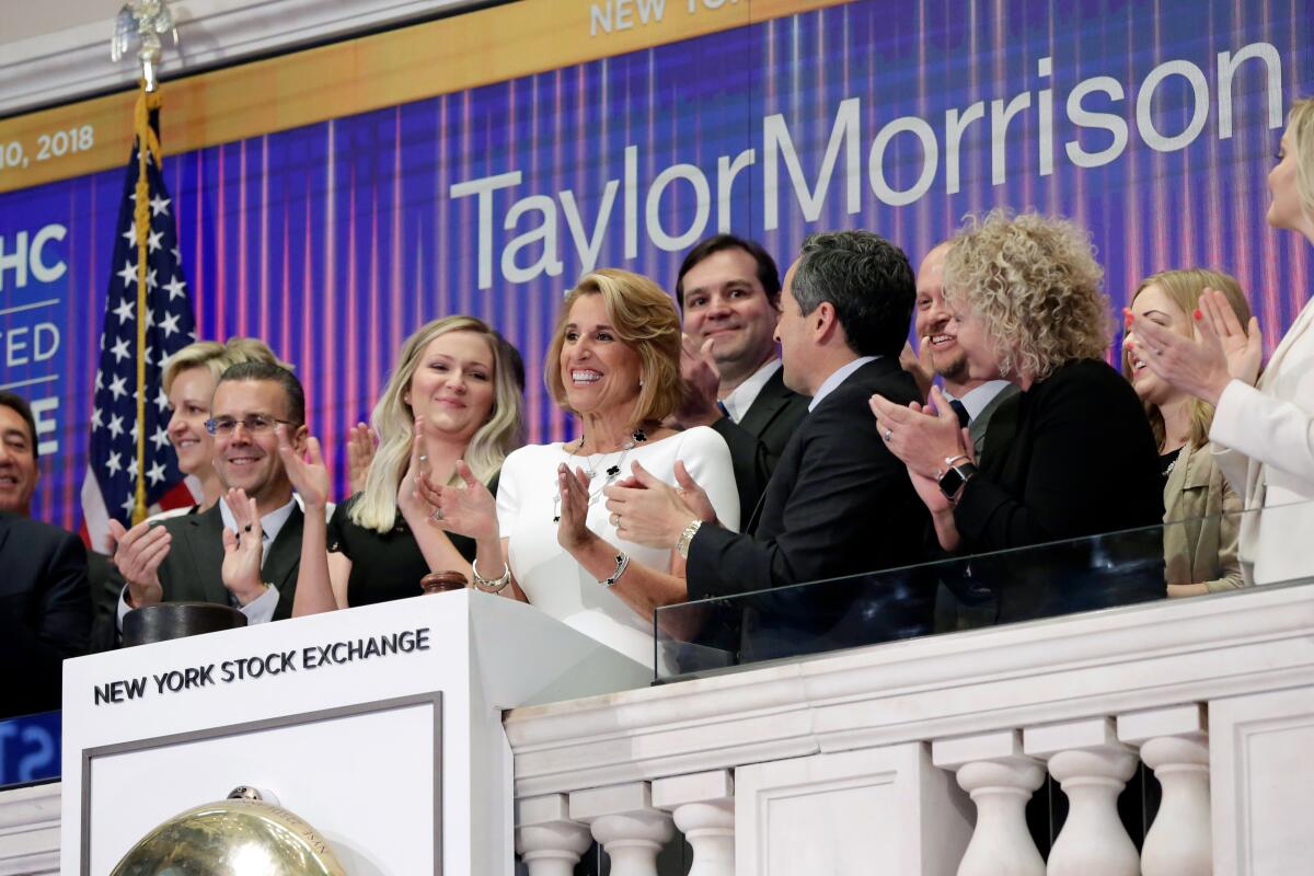 FILE - In this April 10, 2018 file photo, Taylor Morrison Chairman, President and CEO Sheryl Palmer, in white at center, joins applause as she rings the New York Stock Exchange opening bell, to celebrate their fifth anniversary of listing. (AP Photo/Richard Drew, File)