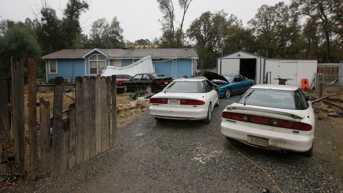 Cars are parked in front of the home of Kevin Janson Neal in Rancho Tehama, Calif. The body of Neal's wife was found at the home, where authorities said Neal started his shooting rampage before being killed in a shootout with police.