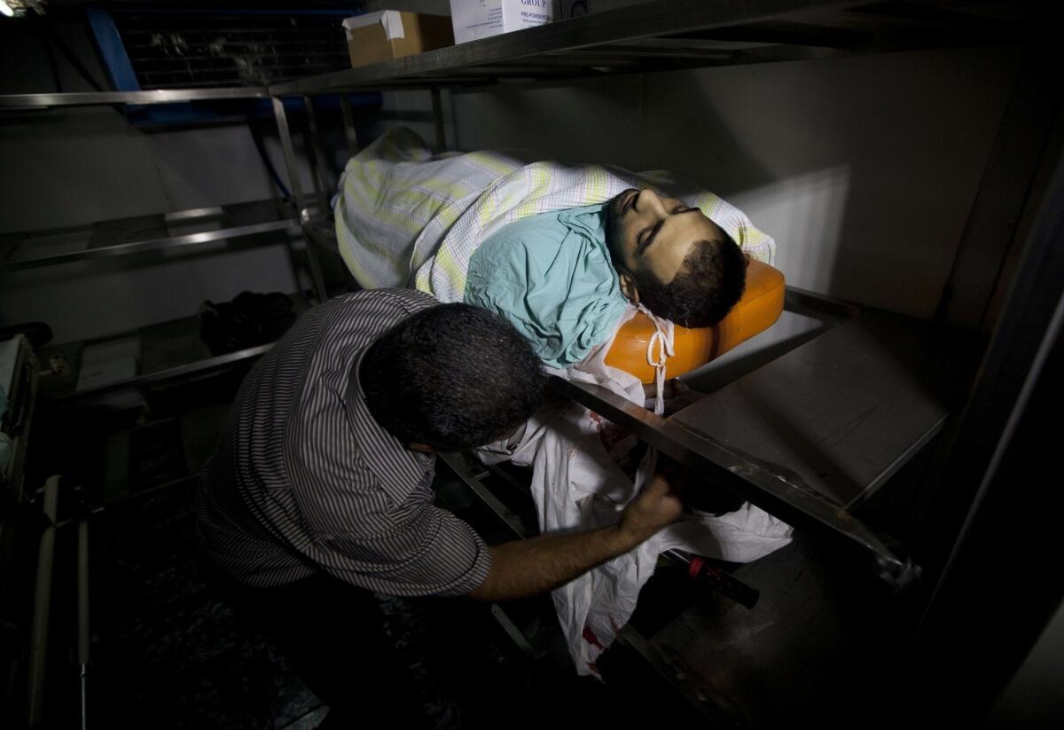 A man at Ramallah Hospital in the West Bank shows the bodies of Palestinian men who were killed during clashes with Israeli security forces in the Qalandia refugee camp.