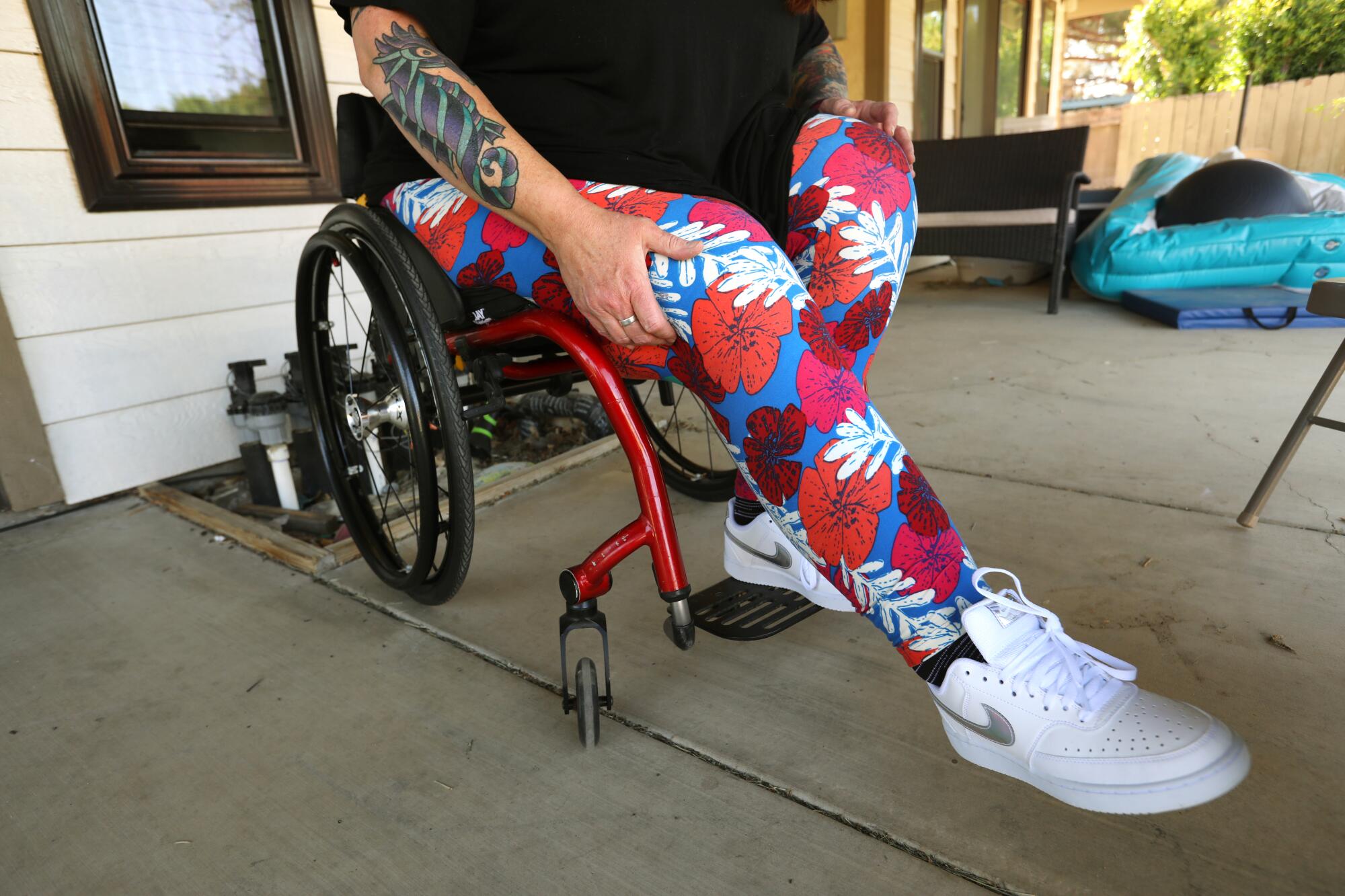 A woman in a wheelchair holds her right leg