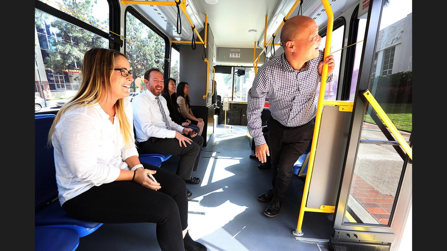 Roy Choi, senior planner with the Burbank Community Development department, looks out the rear door of a new BurbankBus. The new buses run on compressed natural gas.