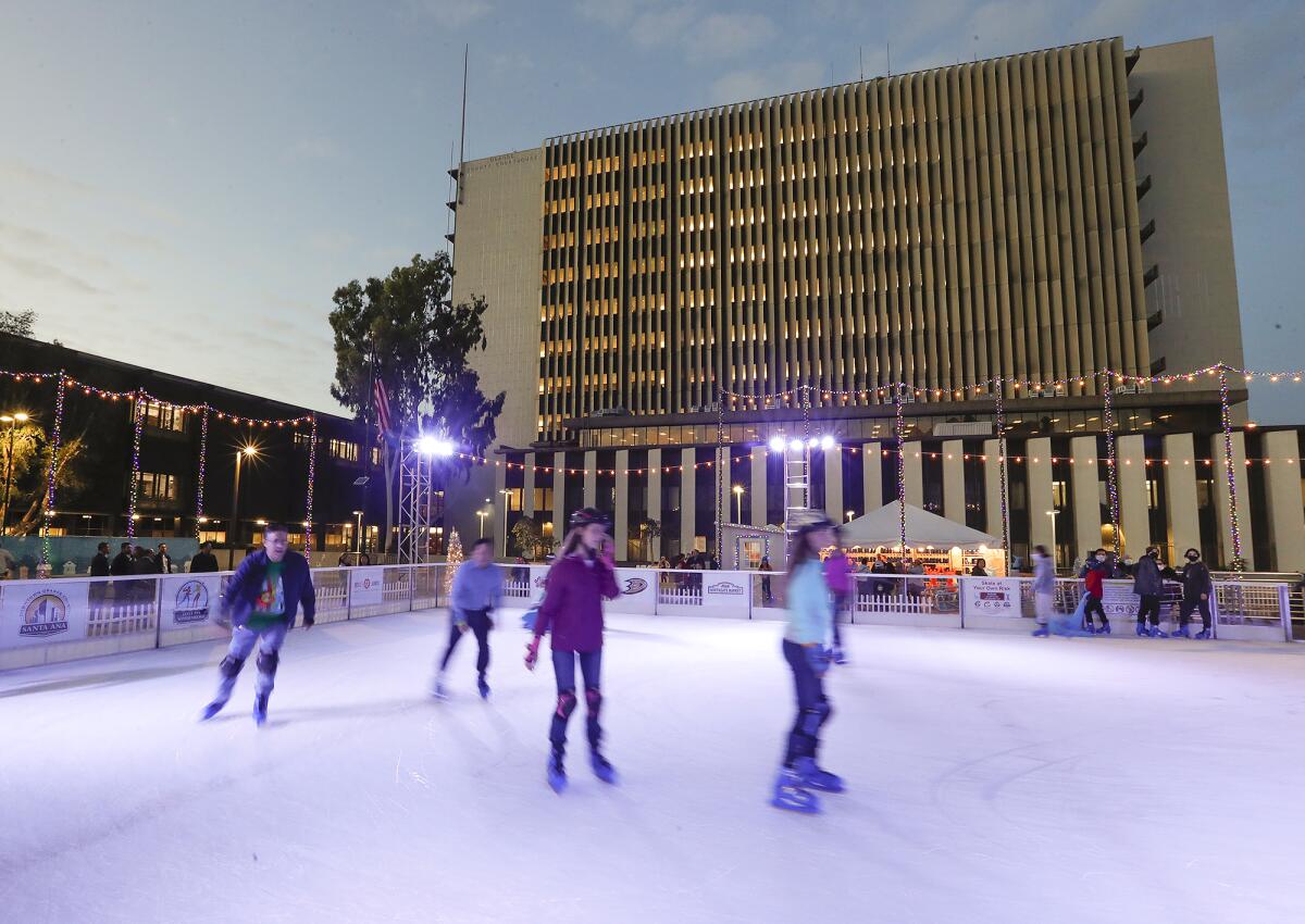 Skaters round the turn at the Santa Ana Winter Village in downtown Santa Ana at the Civic Center Plaza on Tuesday.