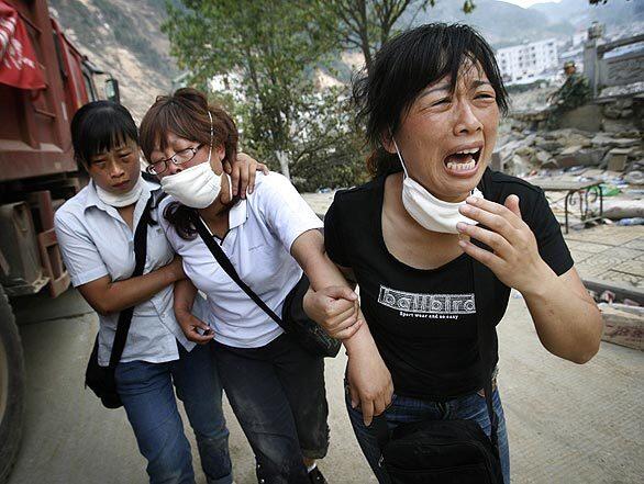 A woman leads relatives to the building in Beichuan, China, where her child was killed in the magnitude 7.9 quake that rocked Sichuan province on May 12. In all, this woman lost 10 family members in the quake, which killed about 70,000 people. Best of 2008 Photography >>> Best of 2008 Main >>>