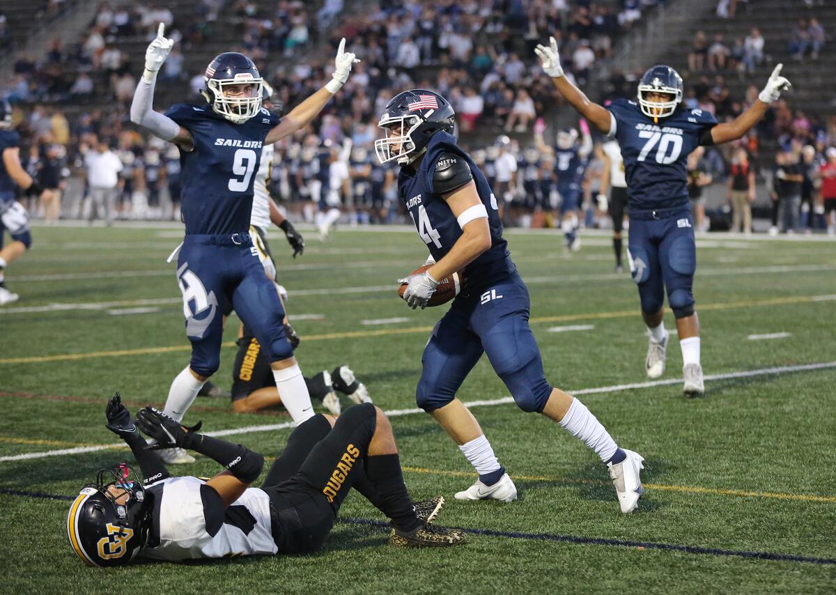 Newport Harbor's Payton Irving (34) crosses the end zone for a score with Duke Starnes (9) and lineman Grayson Simon (70).
