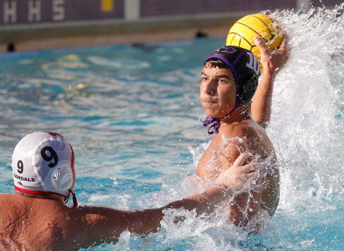Hoover's Samvel Manukyan reaches back to shoot on goal against Glendale's Rudolf Hovhannisyan in a Pacific League boys' water polo match at Hoover High School on Wednesday, October 23, 2019. Hoover defeated Glendale 12-11 after coming from behind in the fourth quarter to win the match.