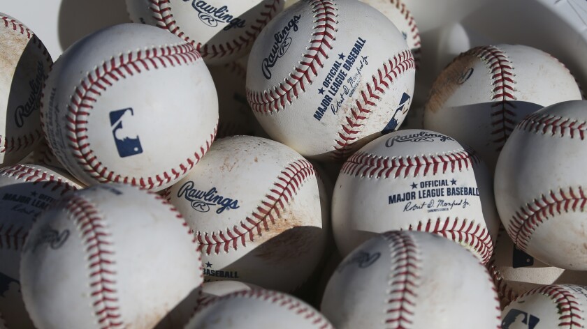 FILE - In this Feb. 14, 2020, file photo, baseballs occupy a bucket after use during fielding practice during spring training baseball workouts for pitchers and catchers at Cleveland Indians camp in Avondale, Ariz. Major League Baseball is suspending all political contributions in the wake of last week's invasion of the U.S. Capitol by a mob loyal to President Donald Trump, joining a wave of major corporations rethinking their efforts to lobby Washington. “In light of the unprecedented events last week at the U.S. Capitol, MLB is suspending contributions from its Political Action Committee pending a review of our political contribution policy going forward,” the league said in a statement to The Associated Press on Wednesday, Jan. 13, 2021. (AP Photo/Ross D. Franklin, File)