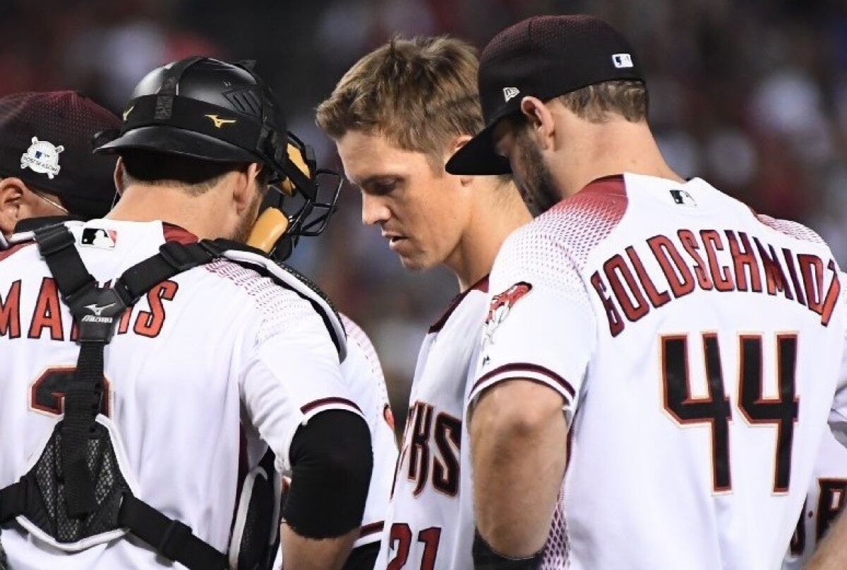Diamondbacks pitcher Zach Greinke, center, looks down as he comes out of Game 3 of the National League division series.