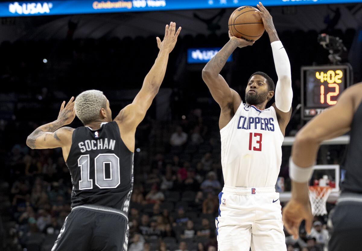 Los Angeles Clippers guard Paul George (13) shoots over San Antonio Spurs forward Jeremy Sochan (10) during the second half of an NBA basketball game, Friday, Nov. 4, 2022, in San Antonio. (AP Photo/Nick Wagner)