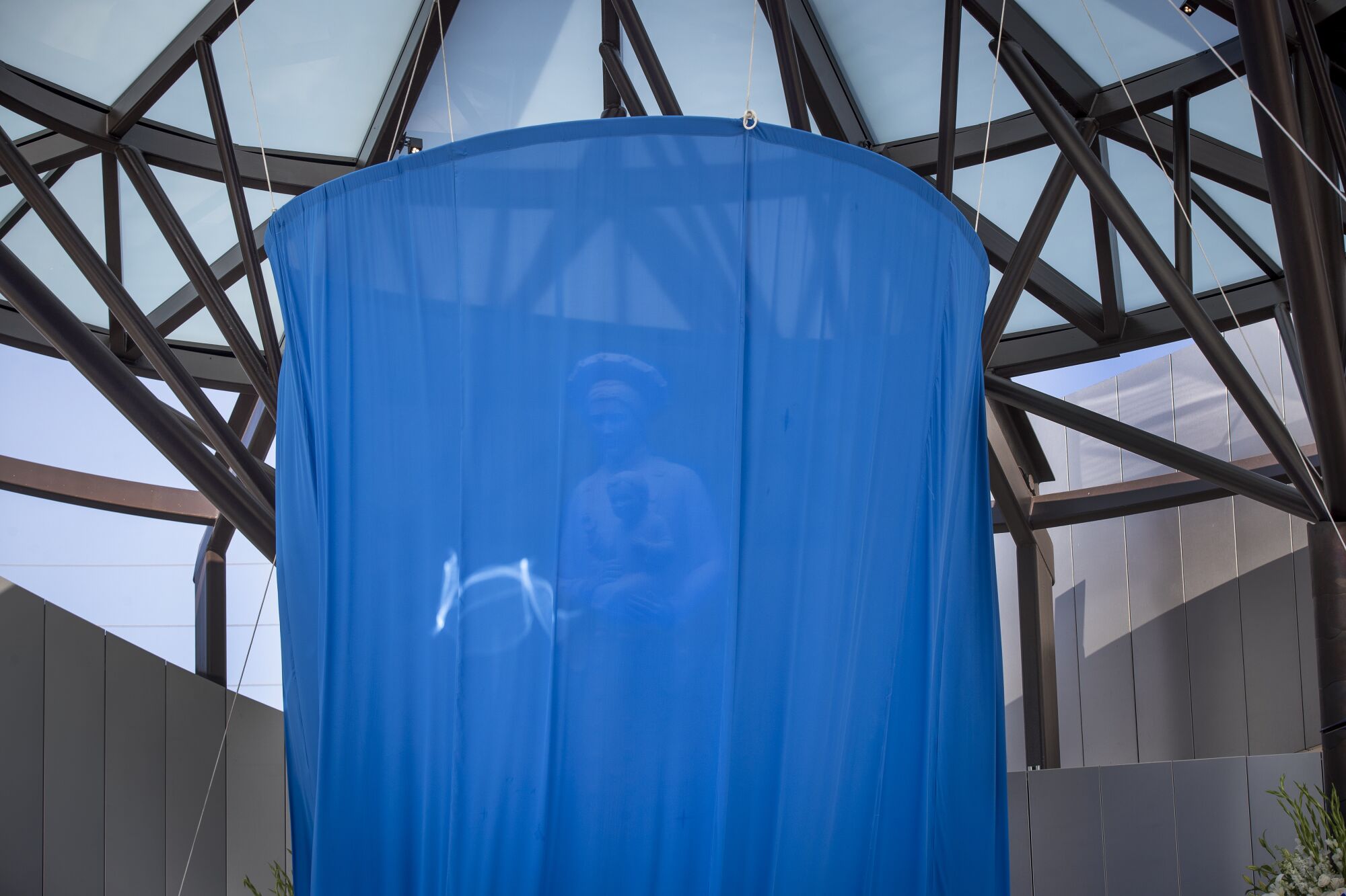 Our Lady of La Vang is seen behind a curtain prior to the unveiling.