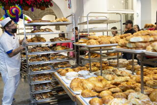 a worker restocks bread supplies.