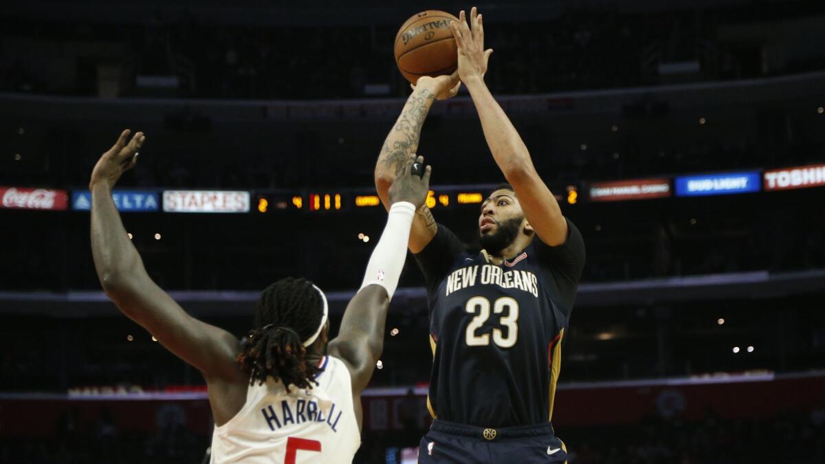 New Orleans Pelicans' Anthony Davis (23) pulls up for a shot while being defended by Clippers' Montrezl Harrell.