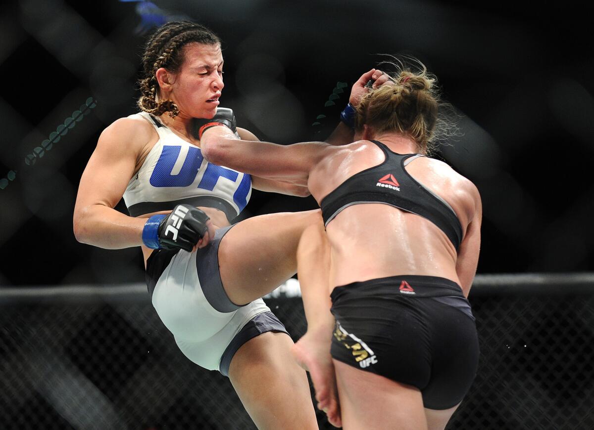 Holly Holm lands a big left against Miesha Tate during their UFC 196 women's bantamweight championship fight.
