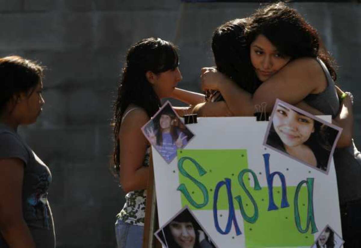 Yuritzi Meza, 16, (far right) hugs Jessica Valiente, (second from right) at a fundraiser for the family of 15-year-old Sasha Rodriguez, who died from a suspected drug overdose during the Electric Daisy Carnival, at Allessandro Elementary School in Los Angeles. Rodriguez's teammates on the 1st Impressions drill team, a hip hop dance team, helped organize the fundraiser for the family.