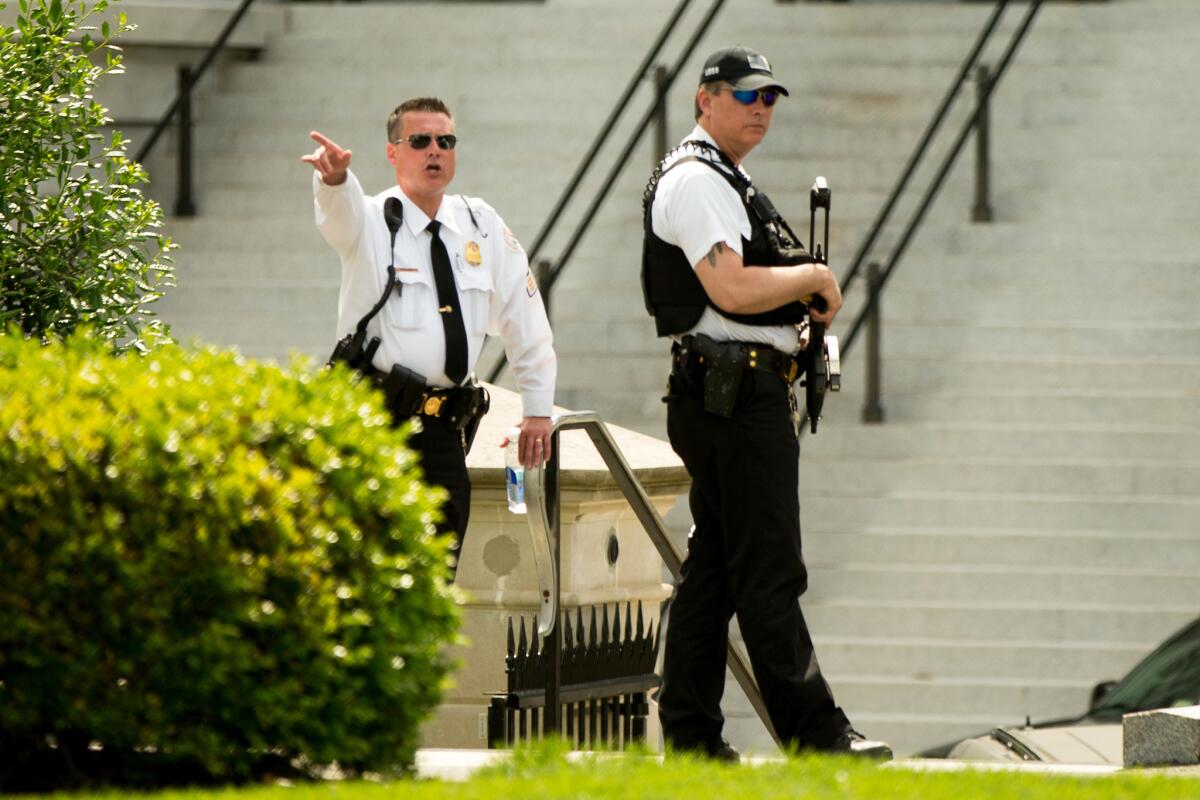A Secret Service agent orders people into buildings near the entrance to the West Wing on Friday after the White House was placed on lockdown after a shooting outside.