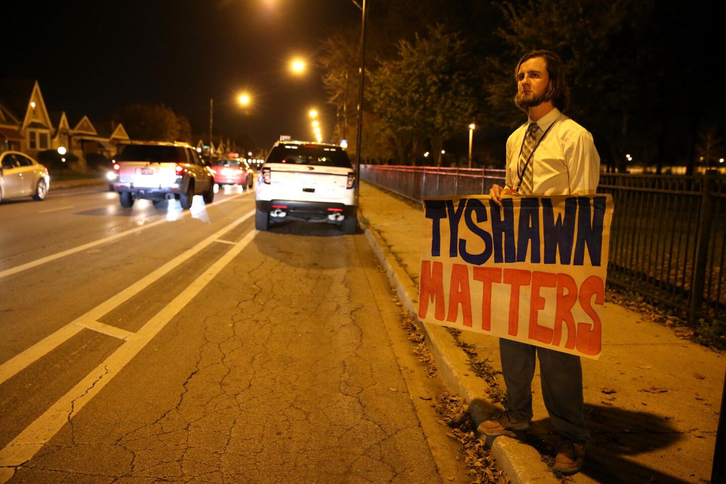 Aaron Fischer holds a sign reading "Tyshawn Matters" while standing in support of the 9-year-old boy Nov. 3, 2015. Tyshawn was shot and killed in an alley near the 8000 block of South Damen Avenue in Chicago on Nov. 2.