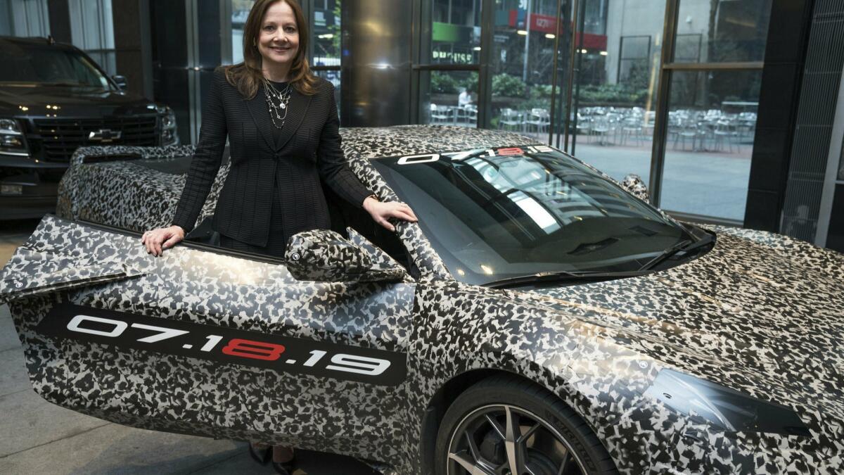 GM CEO Mary Barra with a camouflaged next-generation Chevrolet Corvette in New York. The eighth generation of the sports car, to be unveiled in July, will have its engine tucked between the passenger compartment and the rear wheels.