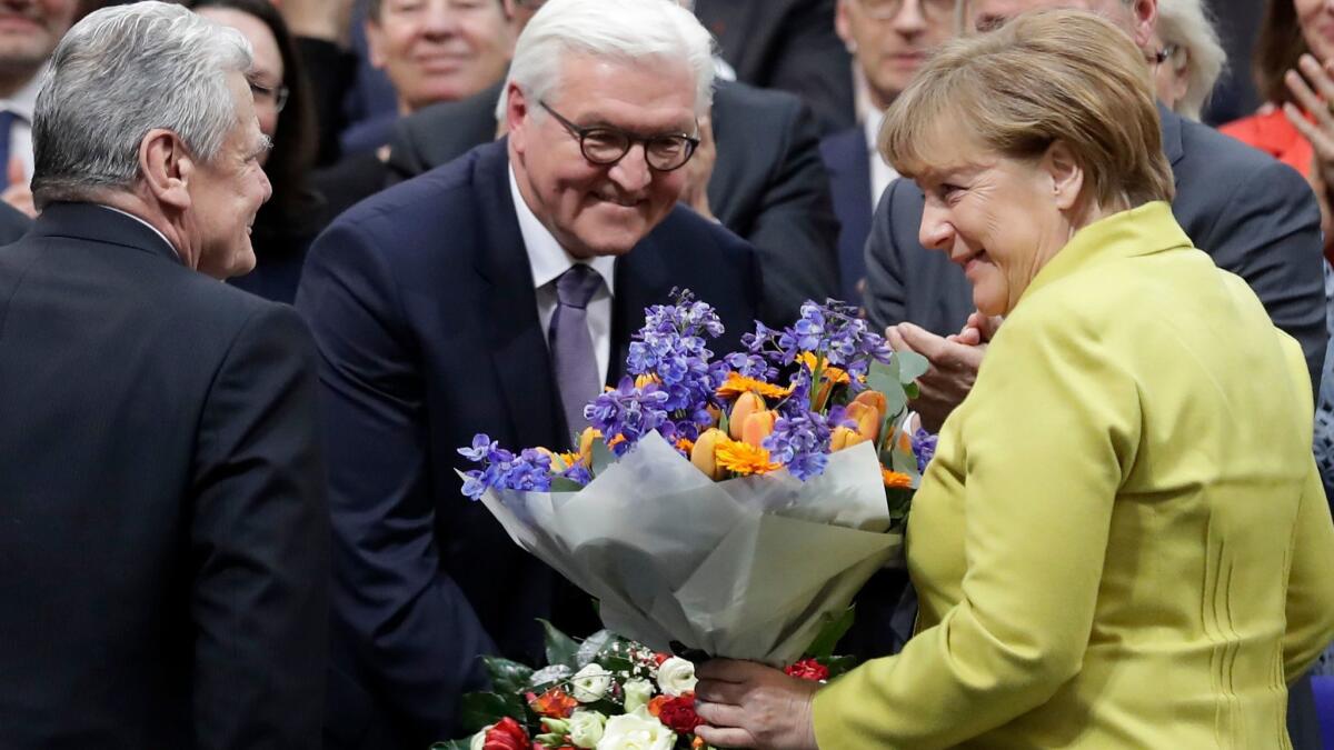 German President-elect Frank-Walter Steinmeier, center, is congratulated by German President Joachim Gauck and Chancellor Angela Merkel on Sunday. Steinmeier takes office March 18.