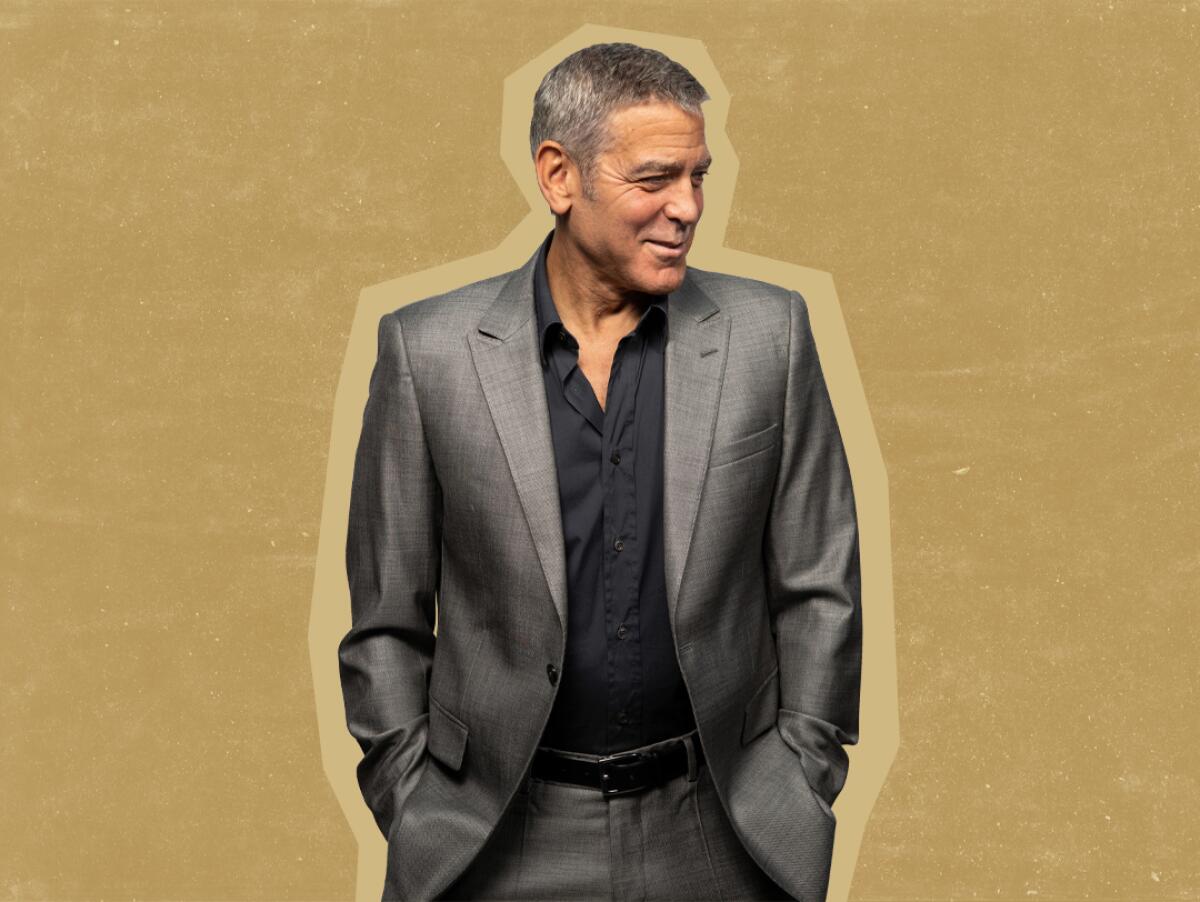 George Clooney stands with his hands in his pockets.