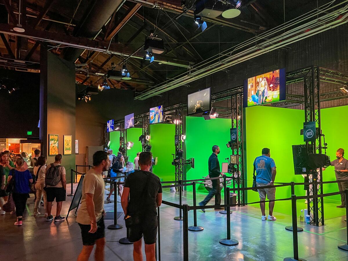 A series of green screens await guests. 