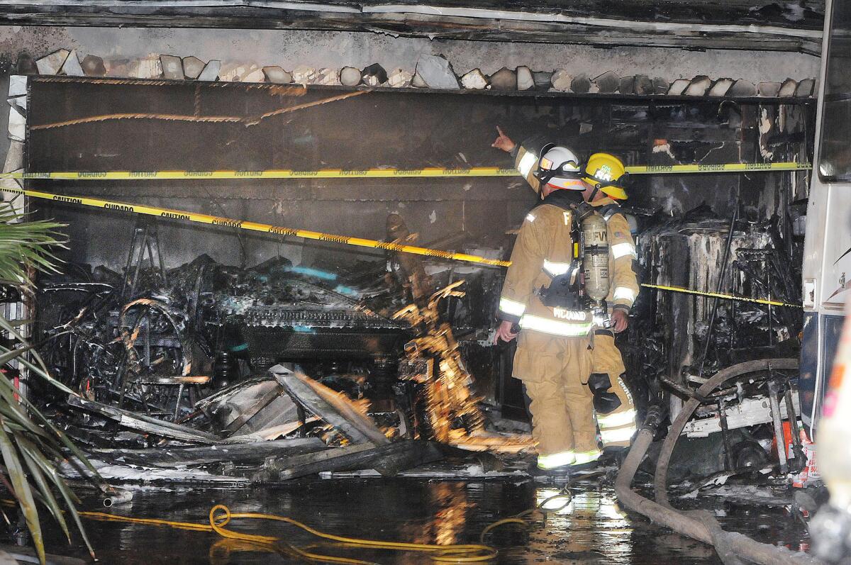 Costa Mesa firefighters survey the damage to a home, where a 7-year-old boy alerted his father to the spreading blaze, allowing the two to escape.