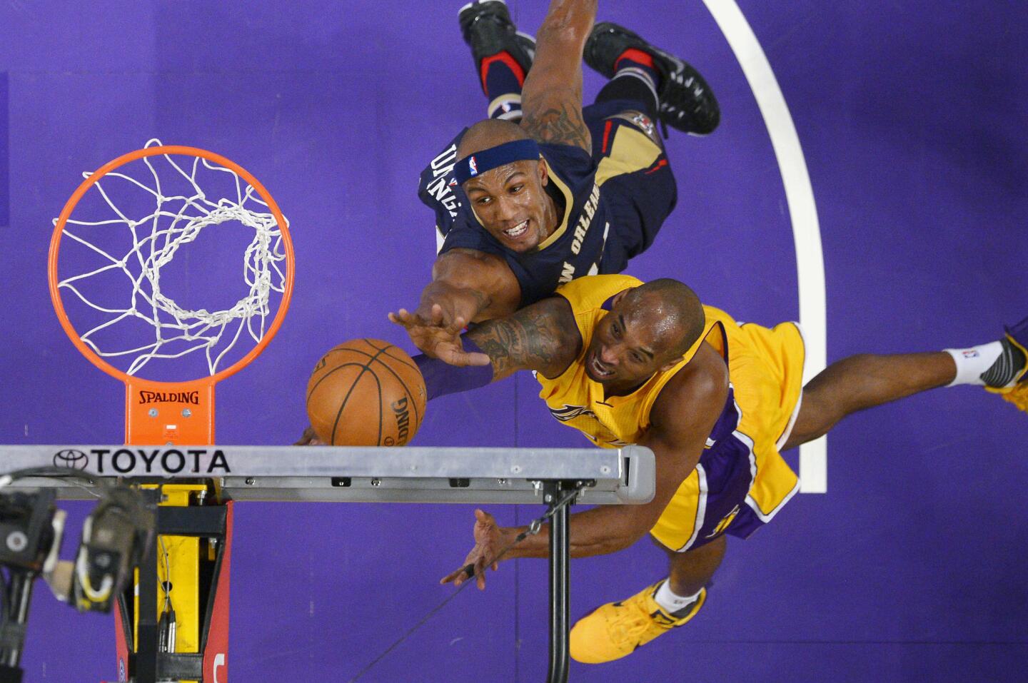 Lakers forward Kobe Bryant, right, shoots as Pelicans forward Dante Cunningham defends during the first half.