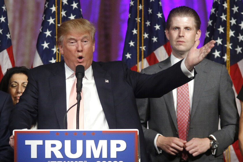 FILE - In this Tuesday, March 15, 2016, file photo, Republican presidential candidate Donald Trump speaks to supporters at his primary election night event at his Mar-a-Lago Club in Palm Beach, Fla. At right is his son Eric Trump. Hits to President Donald Trump’s business empire since the deadly riots at the U.S. Capitol are part of a liberal “cancel culture,” his son Eric told The Associated Press on Tuesday, Jan. 12, 2021, saying his father will leave the presidency with a powerful brand backed by millions of voters who will follow him “to the ends of the Earth.” (AP Photo/Gerald Herbert, File)