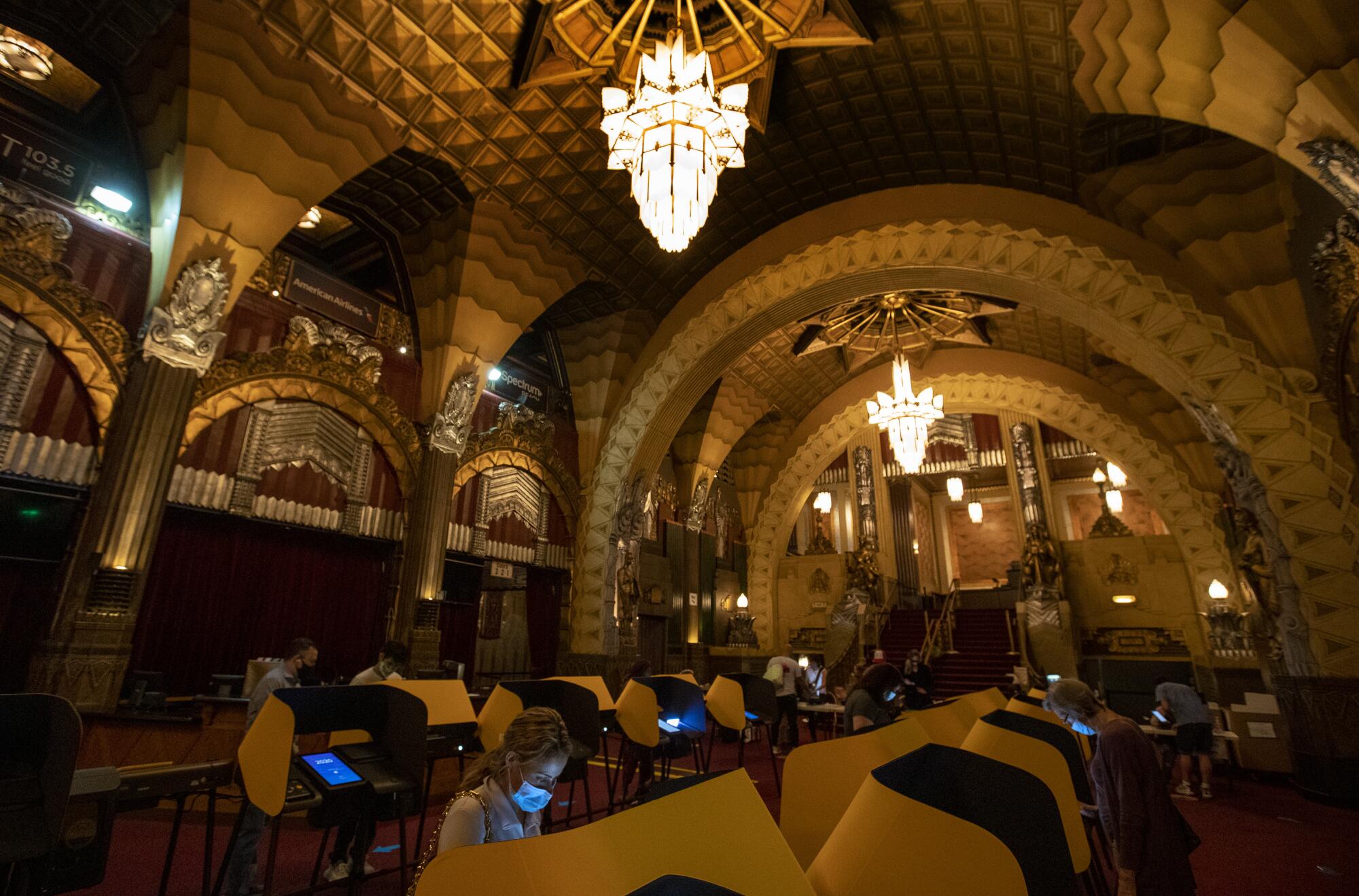 Screens emit a blue light on voters as they cast ballots inside a dark Pantages Theatre on Nov. 2.