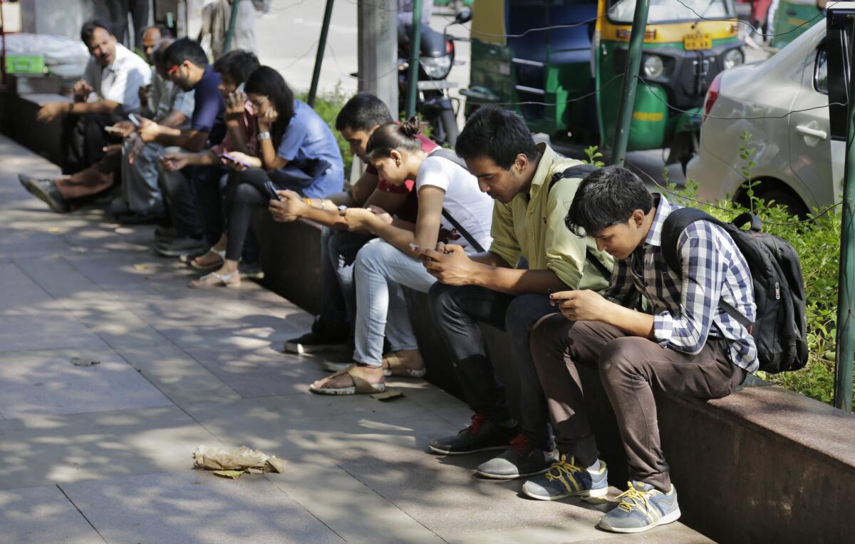 Indians use their mobile phones in New Delhi on Sept. 22.
