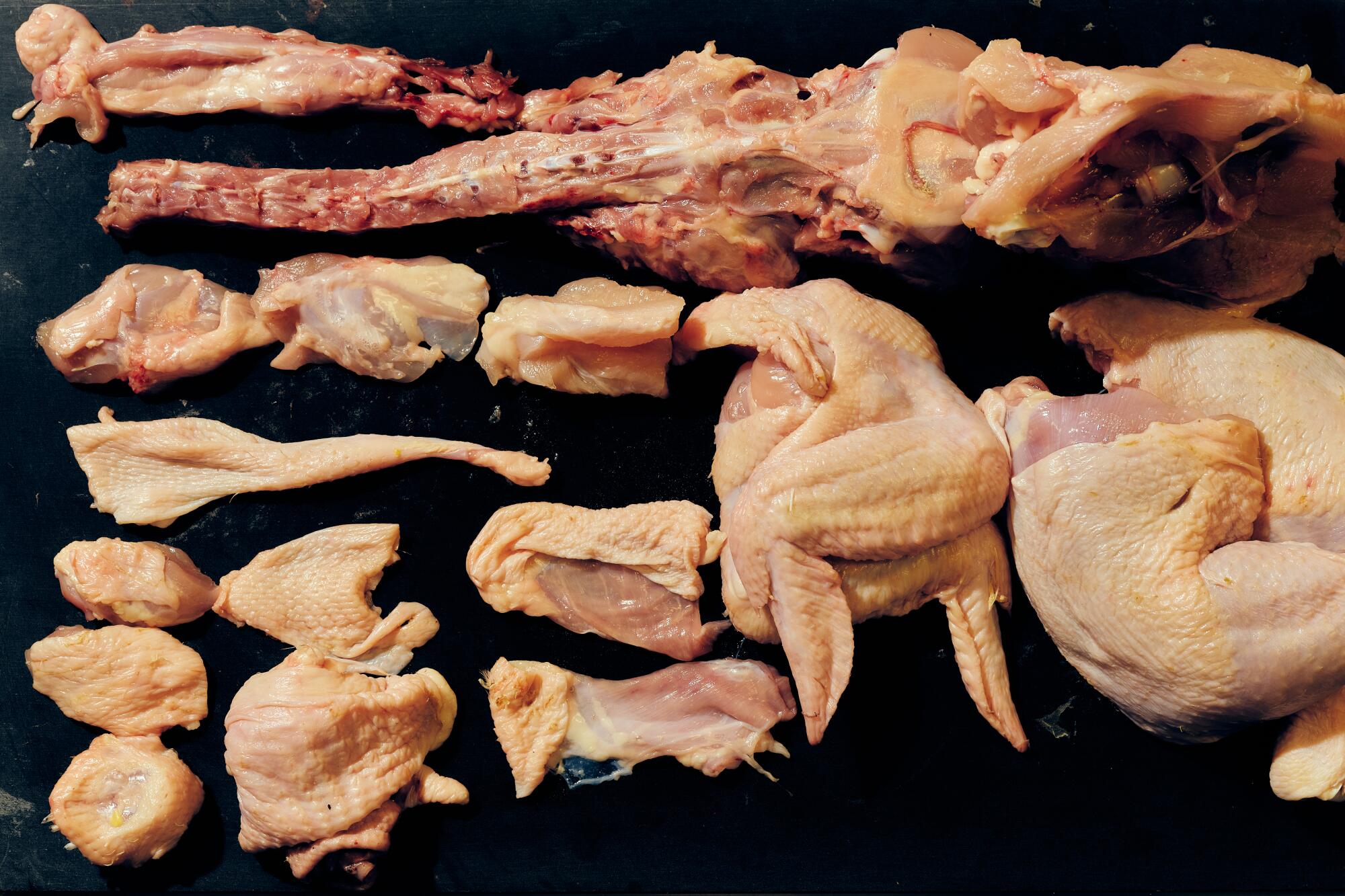 Cut-up chicken arrayed on a board.