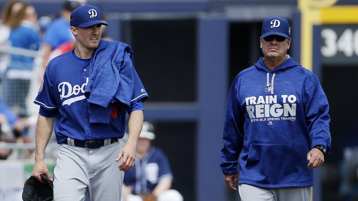 Pitching coach Rick Honeycutt, right, walking with pitcher Ross Stripling at a spring-training game in 2016, is expected back with the Dodgers next season.
