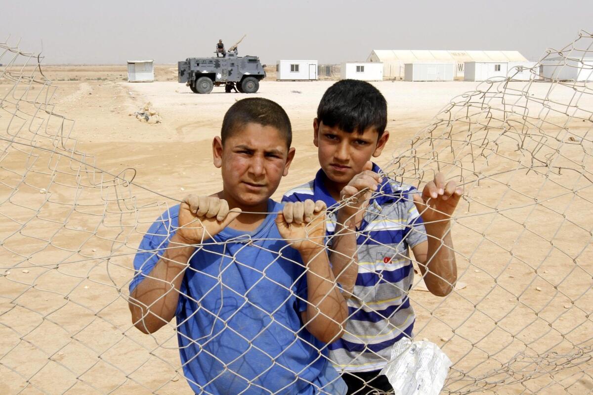 Syrian refugee children watch a soccer training session at the Syrian Zattari refugee Camp in Jordan.