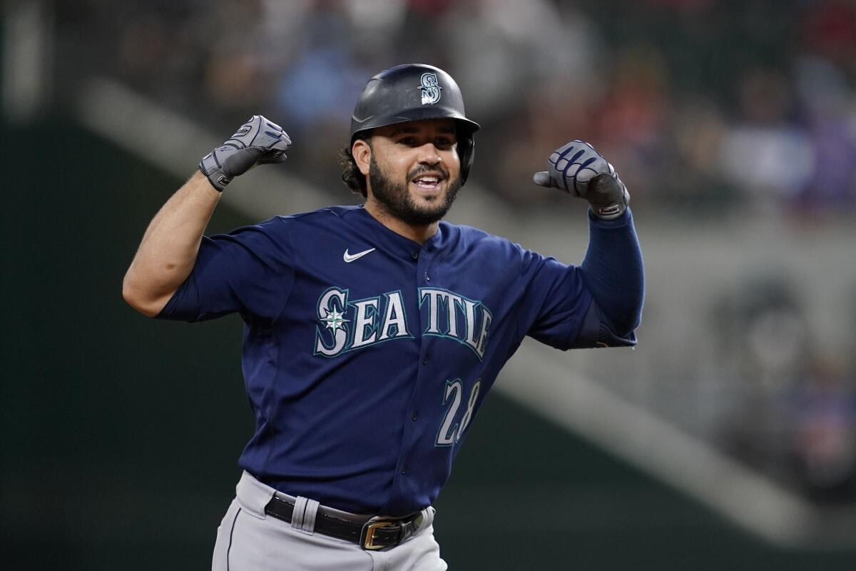 Seattle Mariners' Eugenio Suarez gestures to the dugout as he rounds the bases after hitting a two-run home run against the Texas Rangers in the ninth inning of a baseball game, Friday, June 3, 2022, in Arlington, Texas. (AP Photo/Tony Gutierrez)