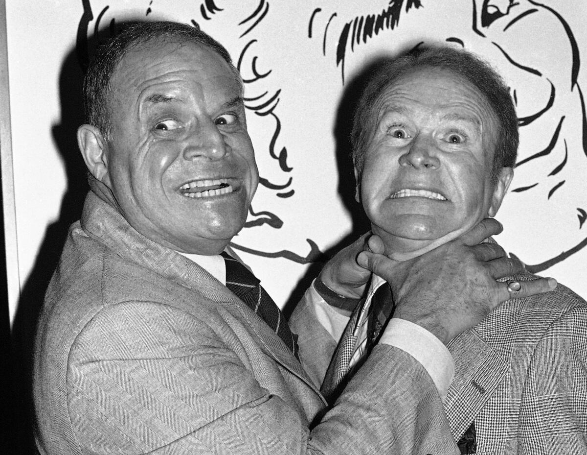 In this Nov. 10, 1977 file photo, Don Rickles pretends to strangle fellow comedian Red Buttons before an annual Stag Roast in Los Angeles.