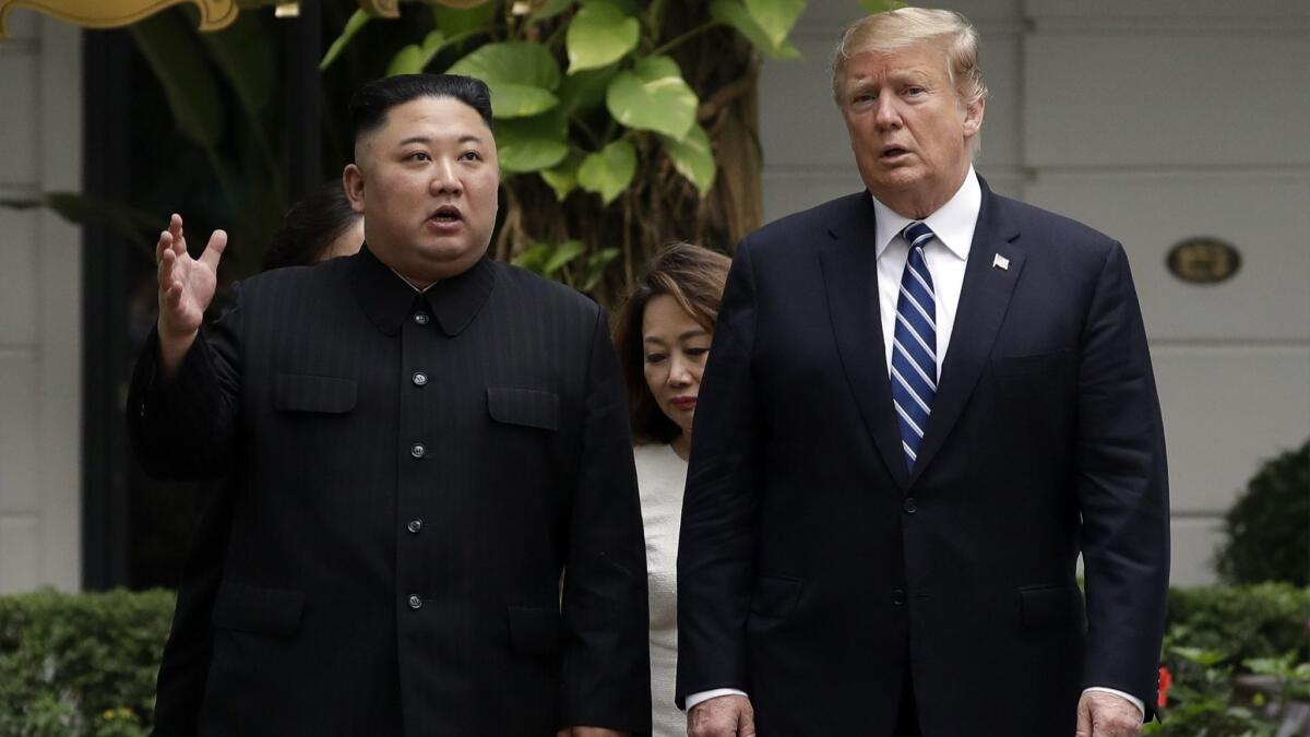 President Trump and North Korean leader Kim Jong Un take a walk during their meeting in Hanoi on Feb. 28, 2019.