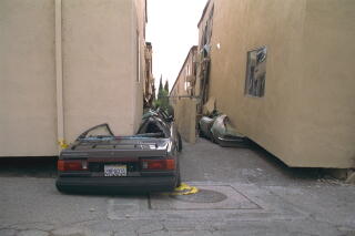 Brown-colored buildings collapsed onto cars
