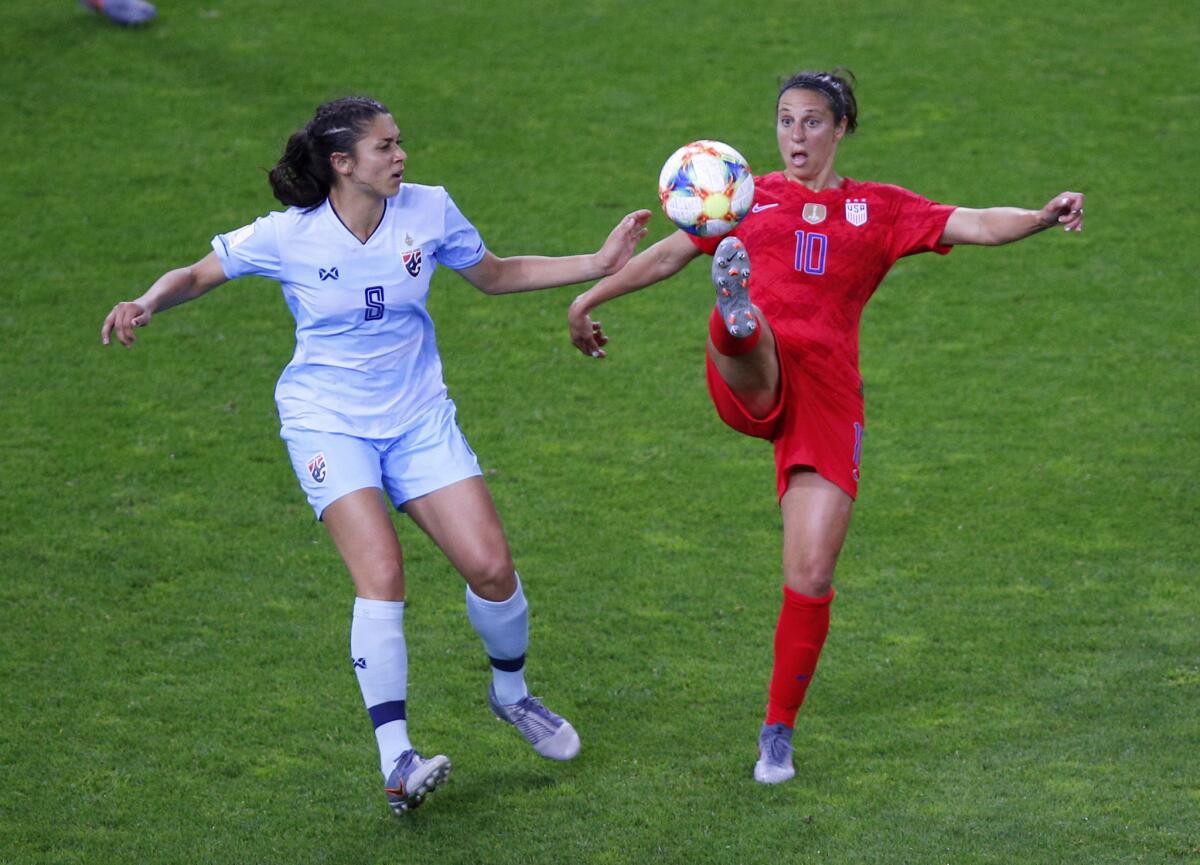 Carli Lloyd of the U.S. attempts to control the ball next to Thailand's Miranda Nild.