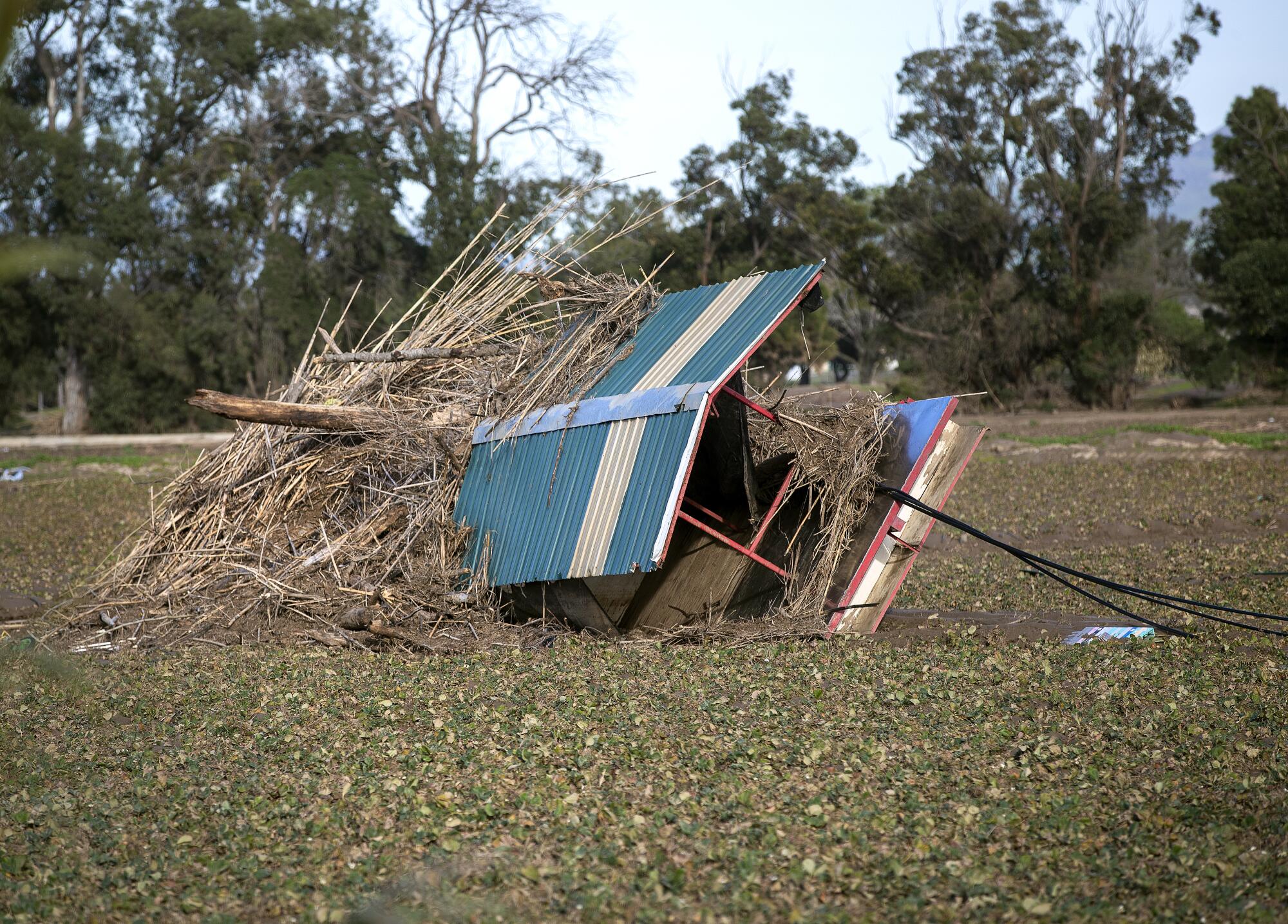 Damaged farm equipment lays covered with debris.