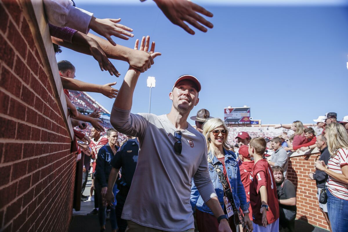 Oklahoma coach Lincoln Riley high-fives fans following a 2019 win over West Virginia 