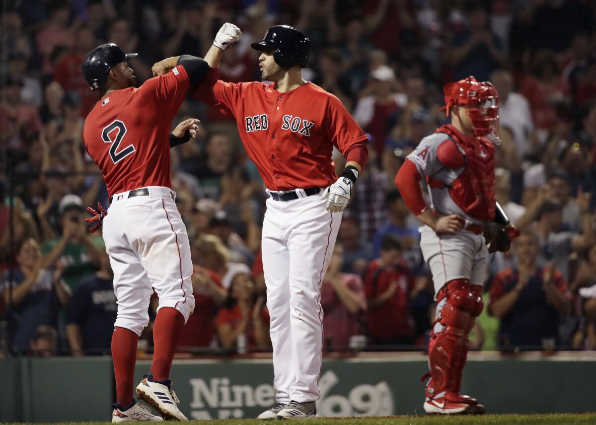 Boston Red Sox's J.D. Martinez, right, celebrates his two-run home run with Xander Bogaerts, next to Angels catcher Max Stassi during the fourth inning on Friday in Boston.