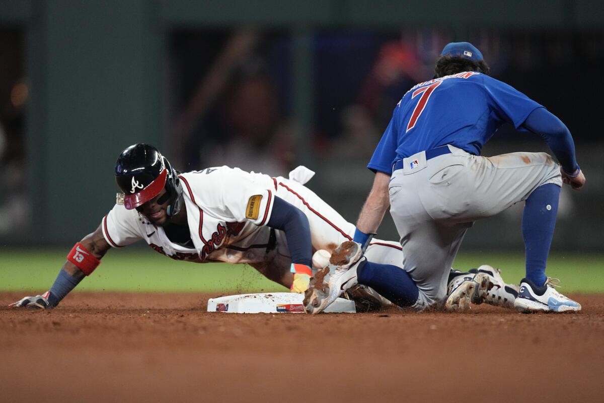Braves' Ronald Acuna Jr. steals second base as the ball gets away from Chicago Cubs shortstop Dansby Swanson.