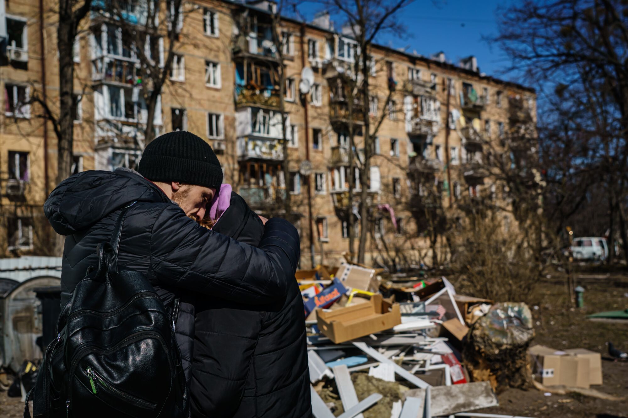 Evheniy Nikolin, left, consoles Evheniya Horho, after a residential area was attacked in Kyiv, Ukraine.