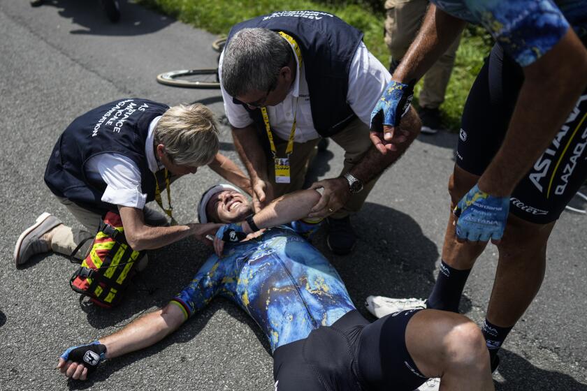 Britain's Mark Cavendish receives medical assistance after crashing during the eighth stage of the Tour de France cycling race over 201 kilometers (125 miles) with start in Libourne and finish in Limoges, France, Saturday, July 8, 2023. (AP Photo/Thibault Camus)