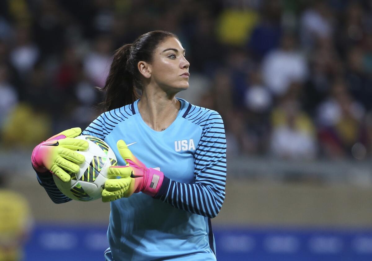 FILE - United States' goalkeeper Hope Solo takes the ball during a women's soccer game.