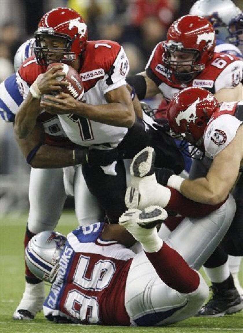 Calgary Stampeders quarterback Henry Burris (1) tackled by Montreal Alouettes running end John Bowman (behind) as Alouettes Devone Claybrooks blocks his path during third quarter of the Canadian Football Leauge Grey Cup in Montreal on Sunday, Nov. 23, 2008. (AP Photo/The Canadian Press, Ryan Remiorz)