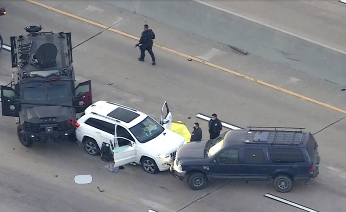 An aerial view of an SUV hemmed in by police vehicles.