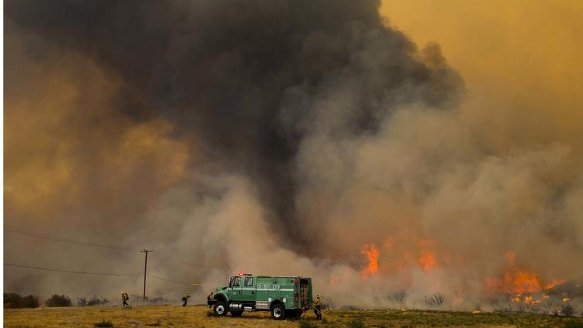 A firestorm approaches as a fire crew begins to pull out at Mormon Rocks Station in the San Bernardino National Forest off Highway 138 last month.