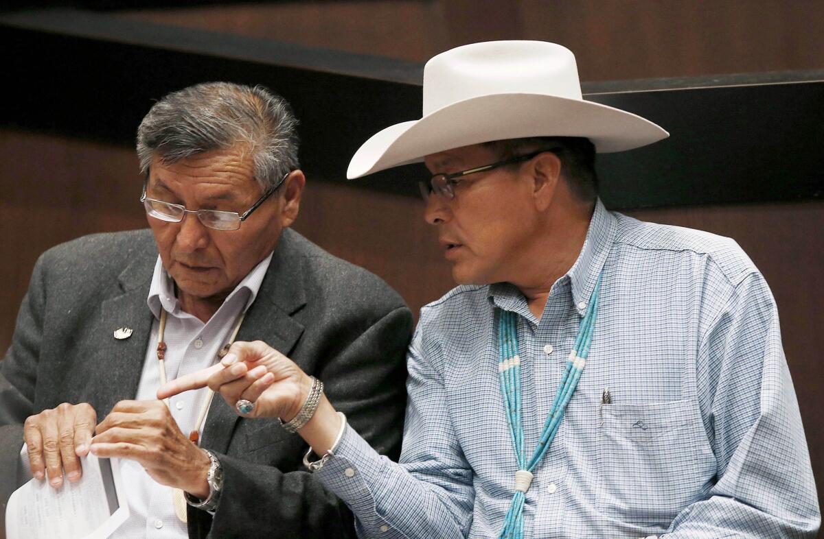 The Navajo Nation will receive $554 million from the U.S. to settle claims of mismanaged funds. Navajo Nation President Ben Shelly, left, talks with tribal presidential candidate Kenneth Maryboy this year.