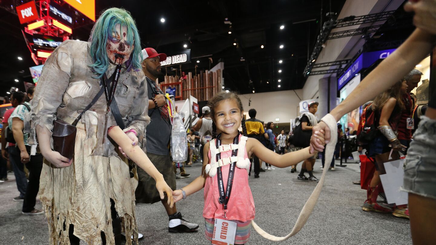 Vienna Wallace, 3, of Temecula, holds the hand of zombie Alyska Gutzwiller, left.