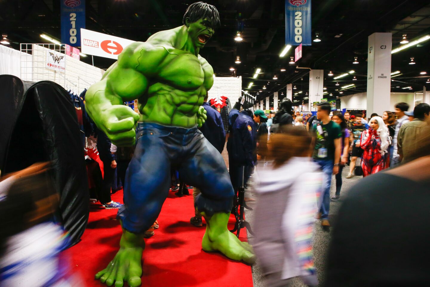 People walk past a statue of Marvel’s the Incredible Hulk at the Anaheim Convention Center.