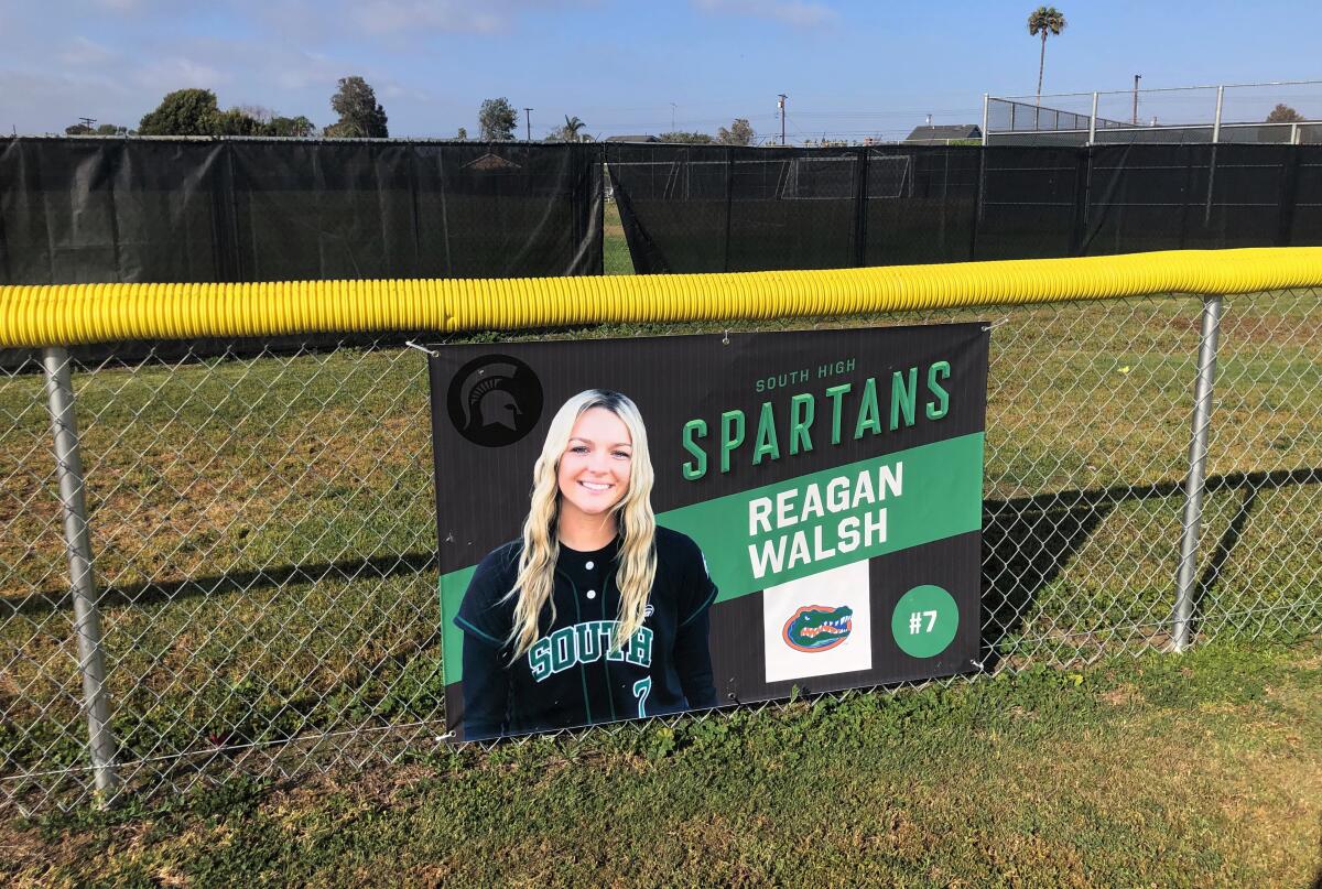 A sign on South Torrance High’s outfield fence displays Reagan Walsh’s college commitment, with the soccer field behind it.